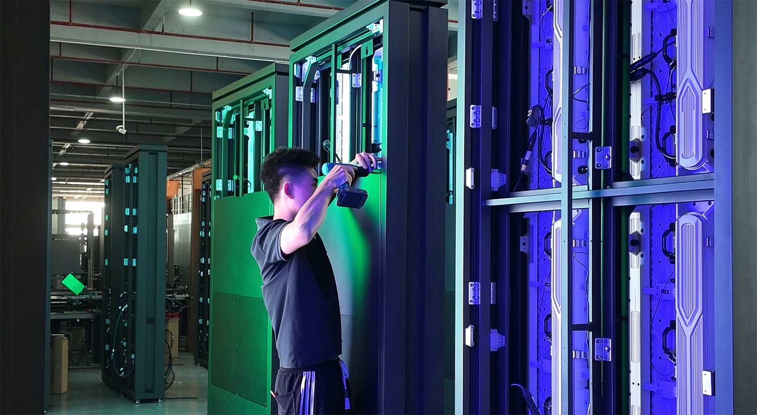 Technicians assembling an outdoor LED totem display during the manufacturing process